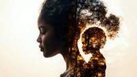 Young African woman silhouette with double exposure effect showing tree branches and sunset sky, representing inner peace, mindfulness and connection with nature.