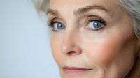 Close-up portrait of mature Caucasian woman with striking blue eyes and silver hair showcasing natural aging and skincare for beauty campaigns.