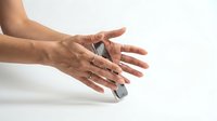 Close-up of hands holding a gray smartphone on white background. Isolated product shot suitable for tech, mobile app, and digital marketing designs.