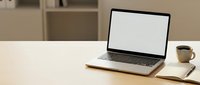 Modern laptop with blank white screen on wooden desk beside coffee cup in minimalist office workspace for business presentations and remote work.