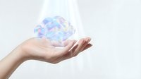Human hand holding holographic brain model representing artificial intelligence, neuroscience research, mental health awareness and cognitive technology innovation.