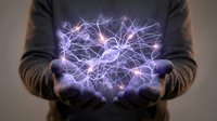 Glowing neural network floating above cupped hands, representing brain activity, artificial intelligence, and neuroscience concepts.