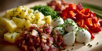 Colorful ingredients for traditional potato salad with diced potatoes, bacon bits, mozzarella balls, red bell peppers, and fresh herbs arranged on wooden cutting board.