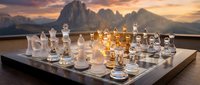 Glass chess set with transparent and frosted pieces on wooden board against dramatic mountain sunset backdrop creating elegant strategic game atmosphere.