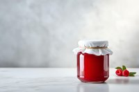 Homemade raspberry jam in glass jar with fresh berries on marble table against light gray background, perfect for food packaging design.