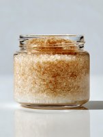 Glass jar filled with brown sugar crystals on light background, minimalist composition for food photography or culinary content.