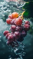 Fresh red grapes with green leaf splashing into water with bubbles and droplets, creating dynamic motion for food and beverage advertising.