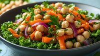 Fresh chickpea salad with kale, carrots and red onion in bowl. Healthy vegetarian meal with legumes and vegetables for nutritious dining and meal prep.