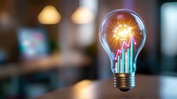 Glowing light bulb with rising colorful bar graph inside, symbolizing business growth, innovation and creative solutions on blurred background.