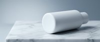 White cylindrical cosmetic bottle mockup on marble surface for skincare product branding and packaging design presentations.