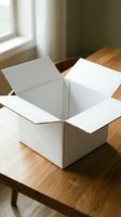 Open white cardboard box on wooden table near window for shipping, moving, packaging and delivery services.