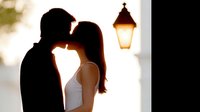 Romantic couple silhouette sharing intimate moment under glowing lantern at sunset, perfect for wedding invitations and love-themed designs.
