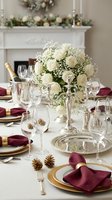 Elegant holiday dining table with white roses centerpiece, burgundy napkins, gold accents, champagne and festive decorations for Christmas celebration.