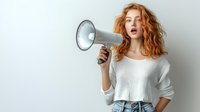 Young redhead woman with curly hair holding megaphone speaking announcement isolated on white background for marketing communication design.