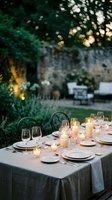 Elegant outdoor dinner table setting with candles and wine glasses in garden at sunset for romantic dining and entertaining events.