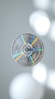 Silver cryptocurrency coin with holographic rainbow reflections floating against soft blurred bokeh background for digital finance and blockchain concepts.