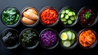 Colorful variety of pickled and fermented vegetables in glass jars viewed from above on dark background. Fresh homemade preserves for healthy eating.