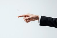 Male hand in business suit pointing with index finger against white background, demonstrating direction or selection gesture for corporate concepts.