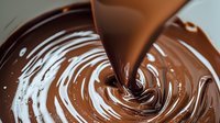 Swirling liquid chocolate creating mesmerizing spiral pattern with smooth pouring stream. Rich brown melted chocolate with glossy texture and dynamic movement for dessert designs.
