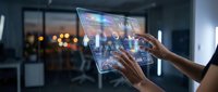 Hands holding transparent tablet displaying holographic interface with digital data visualization and futuristic technology elements in modern office environment.