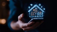 Digital hologram house with smart home icons floating above hand in dark setting with blue glow, representing modern home automation technology.