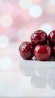 Fresh red cherries with water droplets in white bowl on soft pink bokeh background for healthy eating and summer fruit concepts.