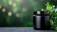 Black cosmetic jar on dark surface against blurred green bokeh background with fresh leaves, mockup for luxury skincare product presentation.