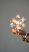 Businessman hand holding glowing puzzle pieces with light effects, representing problem solving, teamwork, and business solutions for corporate and innovation concepts.