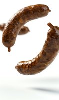 Grilled sausages floating in air on white background, close-up view showing juicy texture and charred surface. Isolated food photography for menu and advertising.