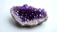 Raw amethyst crystal cluster showing deep purple crystalline formation with white quartz base, displaying natural geometric patterns and mineral growth on isolated background.