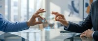 Two business professionals interact with a glowing holographic data interface in a modern office, showcasing futuristic technology and digital innovation.