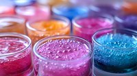 Vibrant fizzy drinks in glasses with colorful pink, blue, and orange carbonated beverages showing bubbles and refreshing effervescence in macro photography.