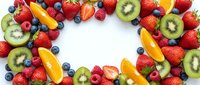 Fresh colorful fruit frame with strawberries, kiwi, oranges and blueberries arranged in circle on white background for healthy eating and nutrition concepts.