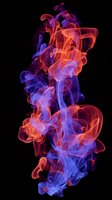 Vibrant red and blue smoke swirls intertwining dramatically against black background, creating ethereal abstract patterns with translucent flowing movement.
