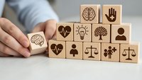 Wooden blocks with healthcare and wellness icons arranged by hands, representing medical services, mental health, and holistic care concepts.