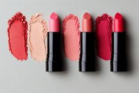 Pink and coral lipsticks with matching powder swatches on light background, arranged in minimalist flat lay composition for beauty and cosmetics marketing.