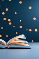 Open book with fanned pages against dark background with glowing golden bokeh lights creating magical reading atmosphere, suitable for education and literature concepts.
