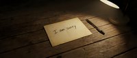 Handwritten I am sorry note on rustic wooden table under warm lamp light, pen beside paper, conveying regret, apology, and emotional sincerity.