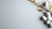 White eggs and delicate yellow spring flowers on branches against light background create minimalist seasonal composition with copy space for text.