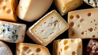 Assorted cheese collection with variety of textures and flavors including blue cheese, swiss, brie and aged hard cheeses arranged in rustic style for gourmet food design.