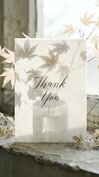 Elegant thank you card with soft leaf shadows on cream paper, surrounded by dried botanicals in a neutral, minimalist autumn setting.