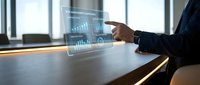 Business professional interacting with holographic data visualization display showing charts and graphs in modern office environment for presentations.