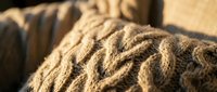 Close-up of natural jute rope coiled in loops, showcasing woven texture and warm earthy tones. Suitable for nautical, industrial, craft, and DIY project backgrounds.