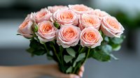 Fresh bouquet of delicate pink roses with soft peach undertones arranged naturally against blurred background, showcasing romantic floral elegance for wedding and celebration designs.