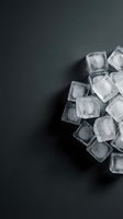 Scattered ice cubes on dark gray surface with ample copy space, suitable for beverage, cocktail, and refreshment marketing materials.