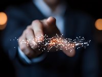 Businessman pointing at glowing digital network connection with sparkle effect against dark background, representing technology innovation and connectivity.