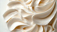 Creamy white meringue texture with soft swirls and peaks creating an elegant wavy pattern, macro food photography showing delicate details and smooth surface.