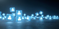 Glowing blue user profile icons scattered across dark surface, representing social media connections or digital network community.