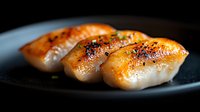 Grilled salmon nigiri sushi with caramelized glaze on black plate, macro shot showing texture and glistening surface in dramatic lighting.