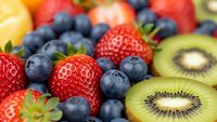 Fresh mixed berries and kiwi slices closeup showing vibrant colors and textures for healthy eating, nutrition concepts, and organic food marketing materials.